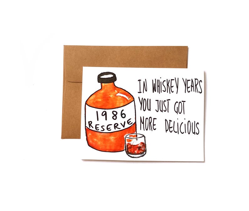 a birthday card for a whiskey lover featuring illustration of a whiskey bottle and a glass.  A label on a bottle reads "1986 reserve." Text on the front of the card says, "In whiskey years you just got more delicious" The card is blank inside