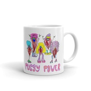 May include: White ceramic mug with a colorful illustration of five figures on roller skates. The figures have exaggerated features and are wearing colorful clothing. The text "Pussy Power" is printed in pink and purple letters at the bottom of the mug.