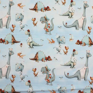 Könnte beinhalten: Ein hellblauer Stoff mit einem sich wiederholenden Muster von Cartoon-Dinosauriern. Die Dinosaurier sind in verschiedenen Posen dargestellt, einige tragen Matrosenmützen und Schwimmwesten. Andere Dinosaurier tragen Krankenschwesternhüte und Matrosenoutfits. Kleine Segelboote und Möwen sind ebenfalls vorhanden.