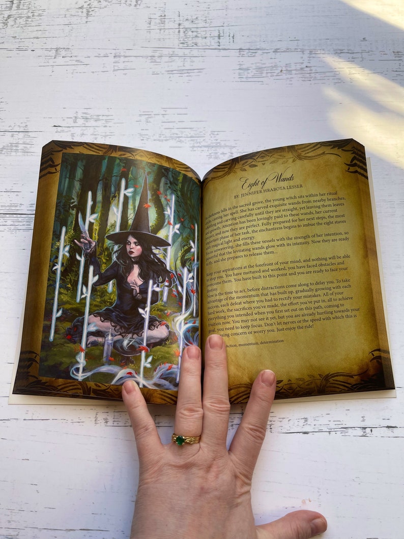 May include: A witch in a black dress and hat sits in a forest setting, surrounded by eight glowing wands. The text "Eight of Wands" is visible in the upper right corner of the image.