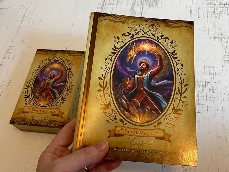 May include: A gold and brown tarot deck box with a gold border and a dragon illustration. The box has the text "78 Tarot Magical Guidebook" and "Written by Trish Sullivan".