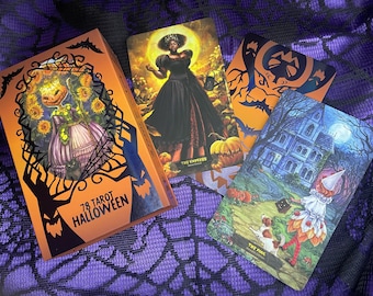 May include: A set of 78 tarot cards with a Halloween theme. The box is orange with black bats and a spider web design. The cards feature illustrations of a witch, a haunted house, and a pumpkin.