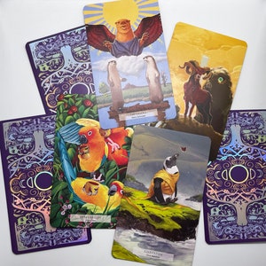 May include: A set of tarot cards with colorful illustrations. The cards feature a variety of imagery, including animals, nature, and abstract designs. The cards are arranged in a circle, with the backs of the cards facing outward. The cards are printed on high-quality cardstock and are durable enough for repeated use.