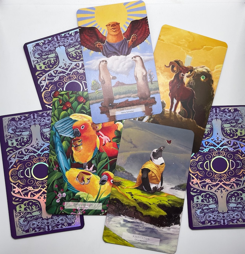 May include: A set of tarot cards with colorful illustrations. The cards feature a variety of imagery, including animals, nature, and abstract designs. The cards are arranged in a circle, with the backs of the cards facing outward. The cards are printed on high-quality cardstock and are durable enough for repeated use.