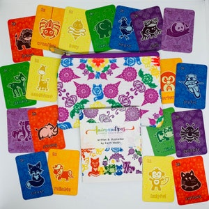 May include: A set of colourful cards with animal illustrations and affirmations. The cards are arranged in a rainbow pattern and feature a variety of animals, including a spider, bee, elephant, chicken, frog, panda, deer, giraffe, rhino, fox, unicorn, butterfly, cow, and cat. The cards are part of a chakra oracle deck called "Animantras".