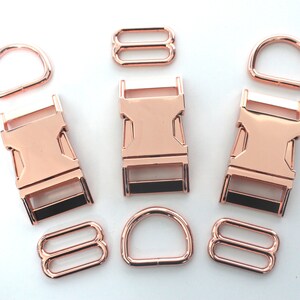 May include: Rose gold metal hardware set, including D-rings, slide adjusters, and side-release buckles. The set is ideal for crafting dog collars, leashes, and other pet accessories. The hardware has a shiny finish.