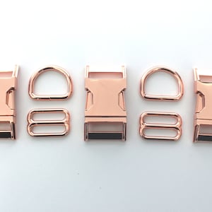 May include: Rose gold metal hardware set including buckles, D-rings, and rectangular rings. The set is displayed on a white background. These components are commonly used in crafting and accessories.