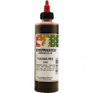 May include: A bottle of Chefmaster Fuchsia Red airbrush color. The bottle has a red nozzle and a label with the product name and ingredients. The liquid inside is a deep red color.