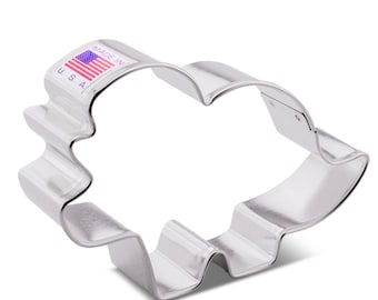 Könnte beinhalten: Silberner Keksausstecher in Form eines Triceratops-Dinosauriers. Der Ausstecher hat einen gewellten Rand und der Text "Made in USA" ist oben aufgedruckt.