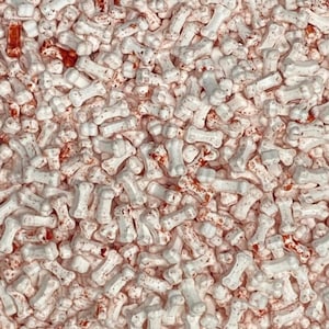 May include: White bone-shaped sprinkles with a red and brown speckled finish. The sprinkles are perfect for decorating cakes, cupcakes, and other desserts.