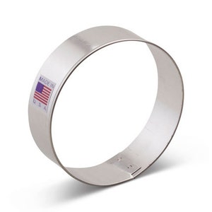 May include: A silver metal cookie cutter shaped like a circle. The cutter has a label that says "Made in USA" with a small American flag.