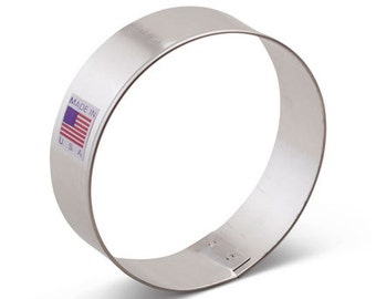 Könnte beinhalten: Ein runder Ausstecher aus silbernem Metall. Der Ausstecher hat ein Etikett mit der Aufschrift "Made in USA" und einer kleinen amerikanischen Flagge.