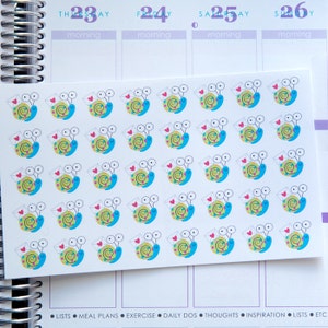 May include: A sheet of colorful snail stickers with a red heart and a white envelope. The snails are blue, green, and yellow with black eyes.