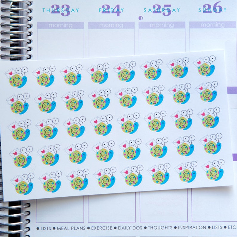 May include: A sheet of colorful snail stickers with a red heart and a white envelope. The snails are blue, green, and yellow with black eyes.