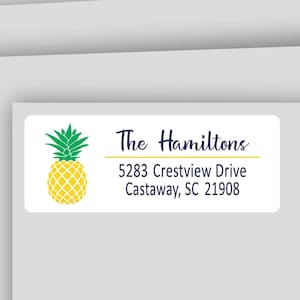 May include: Address labels with a pineapple graphic. The labels include the text "The Hamiltons" and an address. The text "37 Ink Colors to Choose From" and "Address Labels - Available in White or Clear Matte" are also present.