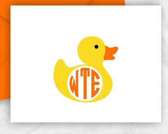 May include: A folded note card with a yellow rubber duck design and orange monogram. The card is paired with an orange envelope. The text "FOLDED NOTE CARDS - BLANK INSIDE" is at the bottom.