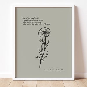 May include: A printable art print with a gray background featuring a black and white line drawing of a flower with the text "Out of the goodnight I was born into your arms Like you're my country Like you're the hills where I belong Love at the End, John Mark McMillan".
