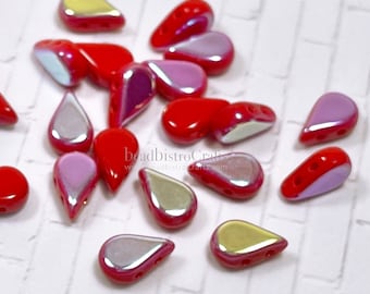 Puede incluir: Una colección de cuentas de cristal en forma de lágrima, de color rojo e iridiscente. Las cuentas tienen dos agujeros y miden aproximadamente 10 mm de largo.