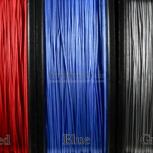 May include: Three spools of thread, one red, one blue, and one gray. The spools are labeled "Red", "Blue", and "Grey".