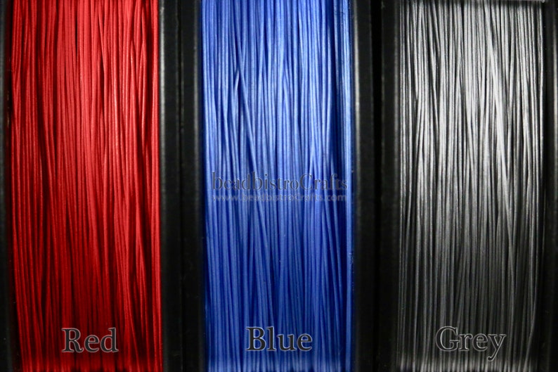 May include: Three spools of thread, one red, one blue, and one gray. The spools are labeled "Red", "Blue", and "Grey".