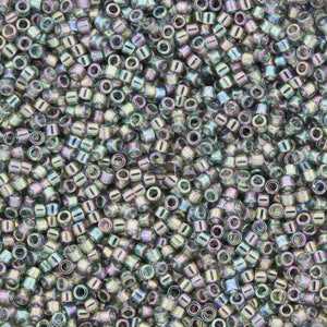 以下が含まれることがあります： イリデセントガラスビーズの山をクローズアップ。ビーズは円筒形で、中央に穴があります。ビーズは銀色、緑色、紫色のメタリックな輝きがあります。これらのビーズは、ジュエリー作りや工芸に最適です。