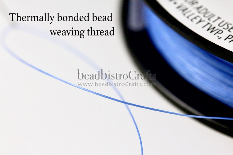 May include: A spool of blue thermally bonded bead weaving thread. The thread is thin and translucent, and the spool is black with white text that reads "For Adult Use Only, Valley Twp., PA".