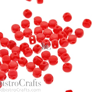 May include: A scattering of bright red round beads with a hole in the center. The beads are made of glass and have a smooth, glossy finish.