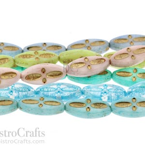 Peut inclure: Un brin de perles de verre ovales avec un motif dor&eacute;. Les perles sont dans des tons de bleu, vert et rose.