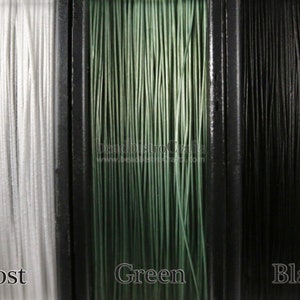 May include: Three spools of thread in different colors: frost, green, and black. The spools are labeled with the color names.