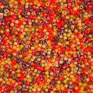 May include: A close-up view of a pile of small, cylindrical beads in shades of red, orange, and yellow. The beads are densely packed together, creating a textured surface. The beads appear to be made of glass or a similar material, with a glossy finish.
