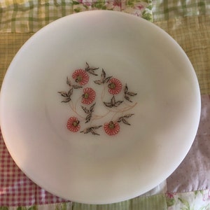 May include: White oval ceramic serving dish with a floral design. The flowers are pink with brown centers and green leaves.