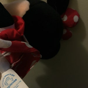 Peut inclure: Un jouet en peluche rouge et blanc &agrave; pois avec des oreilles noires et un visage blanc. Le jouet est &eacute;tiquet&eacute; "applause" et porte le texte "Everyone loves to get applause" sur l'&eacute;tiquette. L'&eacute;tiquette comprend &eacute;galement les informations "Woodland Hills, CA 91365, Made in China, Surface Wash, Air Dry."