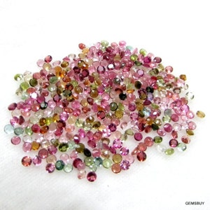Puede incluir: Un mont&oacute;n grande de peque&ntilde;as piedras preciosas redondas multicolores. Las piedras preciosas son principalmente rosas, verdes y marrones, con algunas piedras preciosas transparentes y azules mezcladas.