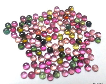 May include: A collection of round, multi-colored gemstones. The gemstones are a mix of pink, green, and yellow. The gemstones are all about the same size and are arranged in a random pattern.