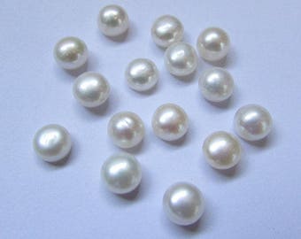 May include: A collection of 16 white round pearls, each approximately 6mm in diameter. The pearls are arranged in a random pattern on a white surface.