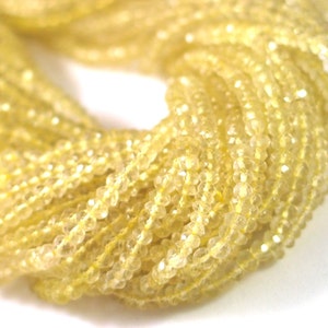 May include: A strand of yellow faceted gemstone beads. The beads are small and have a smooth, polished finish.