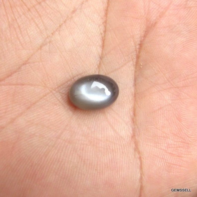 May include: A gray oval-shaped gemstone with a star-like pattern in the center.