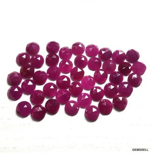Peut inclure: Une collection de 30 cabochons de pierres précieuses de couleur rubis rouge facettées. Les cabochons sont tous de taille et de forme approximativement identiques et présentent une finition lisse et polie.