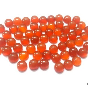 May include: A collection of 40 orange carnelian cabochons, each measuring approximately 10mm in diameter. The cabochons are smooth and polished, with a warm, orange hue.