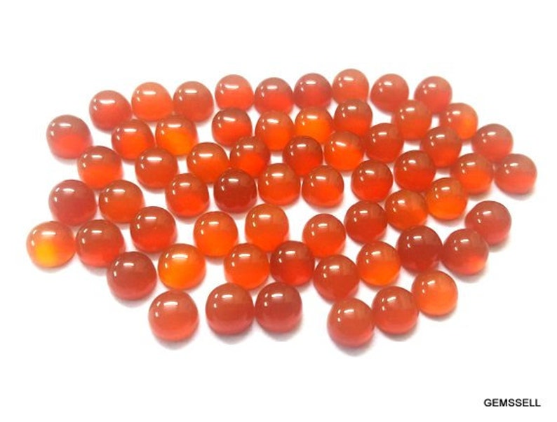 May include: A collection of 40 orange carnelian cabochons, each measuring approximately 10mm in diameter. The cabochons are smooth and polished, with a warm, orange hue.