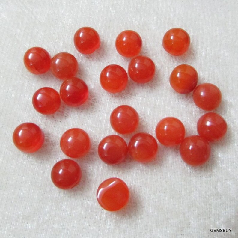 May include: Twenty-two round, orange carnelian cabochons. The cabochons are smooth and polished.