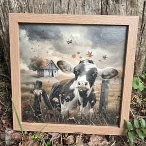 May include: A black and white cow with a crown of autumn leaves stands in a field with a weathered barn in the background. The cow is looking directly at the viewer with a gentle expression. The scene is painted in a realistic style with soft, muted colours.
