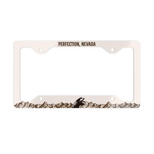 May include: White metal license plate frame with the text "PERFECTION, NEVADA" and a brown silhouette of mountains with a bear in the center.