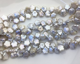 Peut inclure: Un brin de perles d'eau douce blanches en forme de fleur. Les perles ont un reflet irisé.