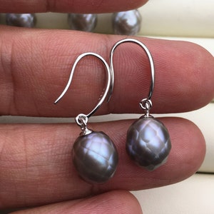 May include: A pair of silver drop earrings with a dark grey, iridescent, faceted pearl on each earring.