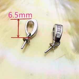 Könnte beinhalten: Zwei silberne Perlenverschlüsse mit einer Öffnung von 6,5 mm. Ein Verschluss hat eine Reihe von klaren Zirkonia-Steinen.