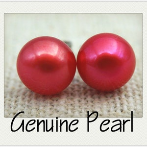 May include: Two bright pink pearl earrings. The pearls are round and smooth, with a glossy finish.