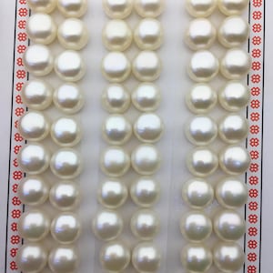 Puede incluir: Una tarjeta blanca con las palabras "High Fashion" impresas en ella. Hay 3 filas de 8 perlas blancas en la tarjeta.