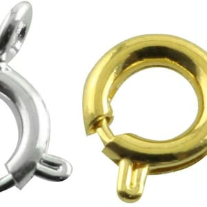 May include: Two metal clasps, one silver and one gold, for jewellery making. The clasps are round with a small loop on the side.