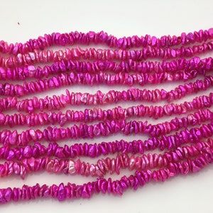 Könnte beinhalten: Eine Strähne aus rosa schillernden Muschelperlen. Die Perlen sind unregelmäßig geformt und haben eine glänzende Oberfläche.